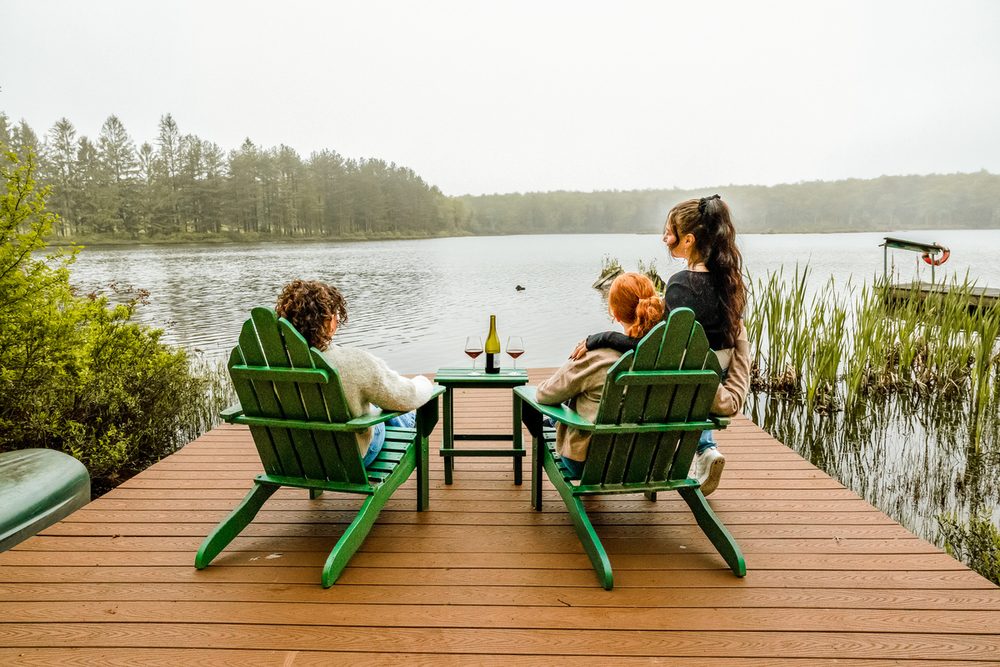 Adirondack chairs on the private dock overlooking the lake, a five-minute walk through the woods from the cabin