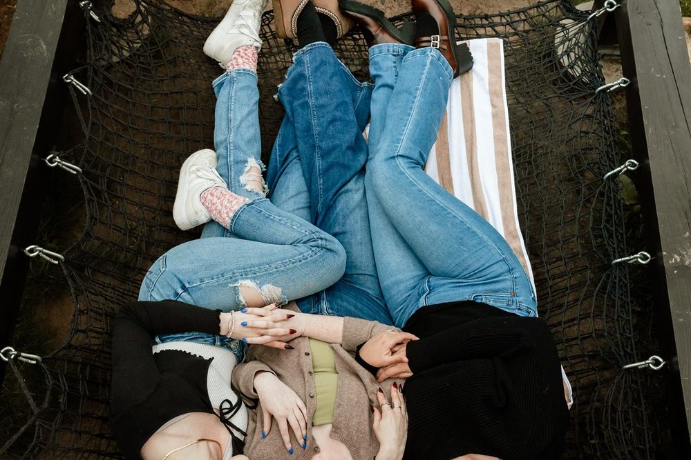 Friends lying together in the suspended lounge net beside the cabin