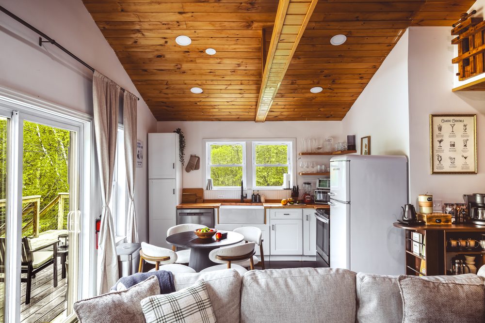 Open-plan living space with vaulted wood ceilings, seating area and full kitchen
