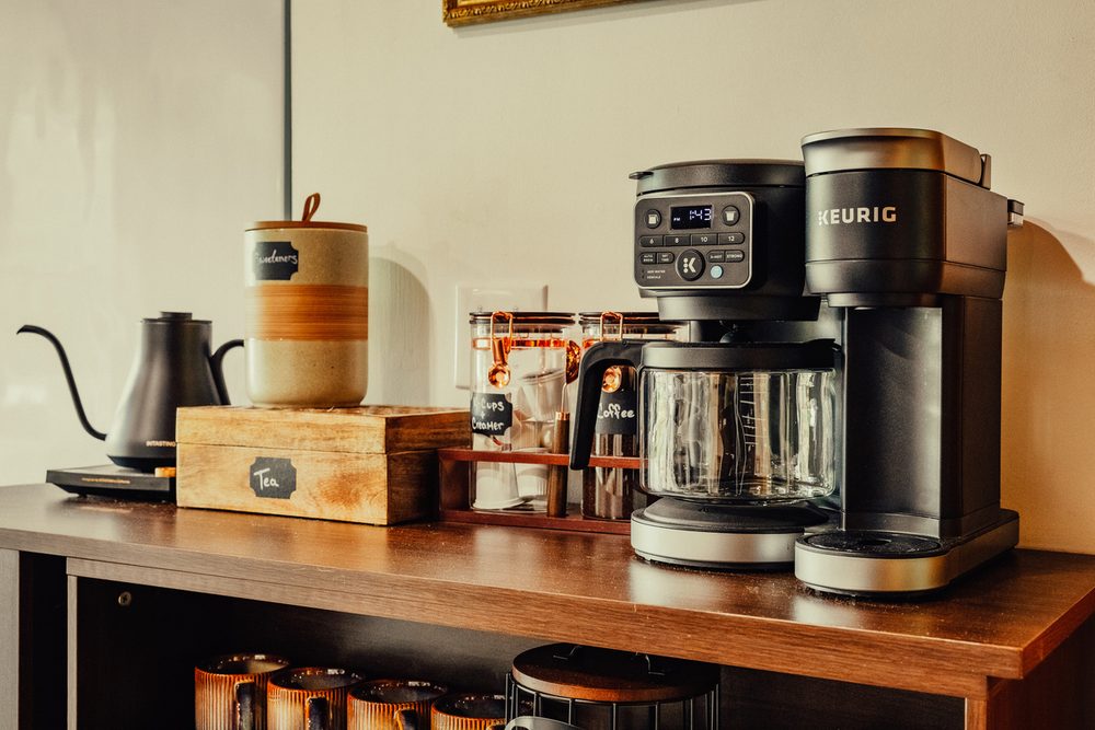 Keurig, drip coffee maker and espresso machine lined up on the kitchen counter