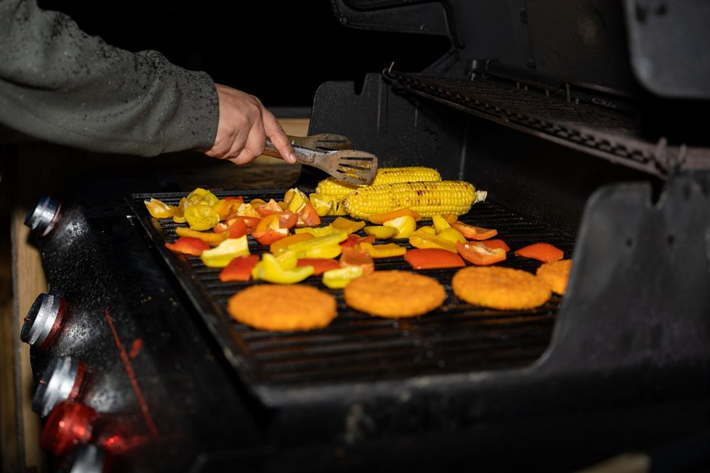 Gas grill on the deck surrounded by woods