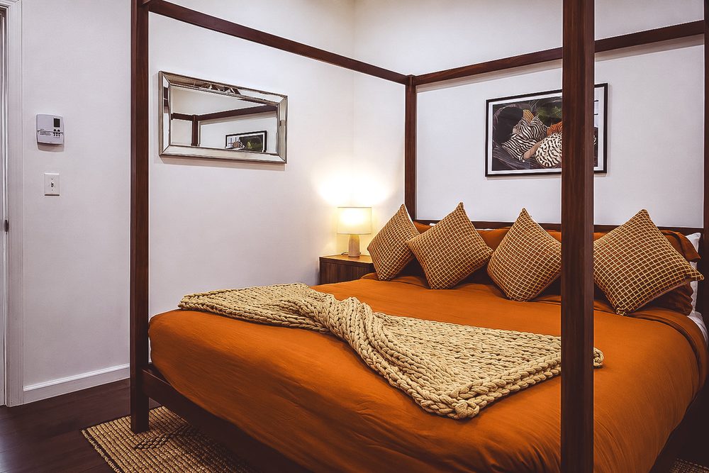 Four-poster king bed with warm linens in the New York Heritage Room