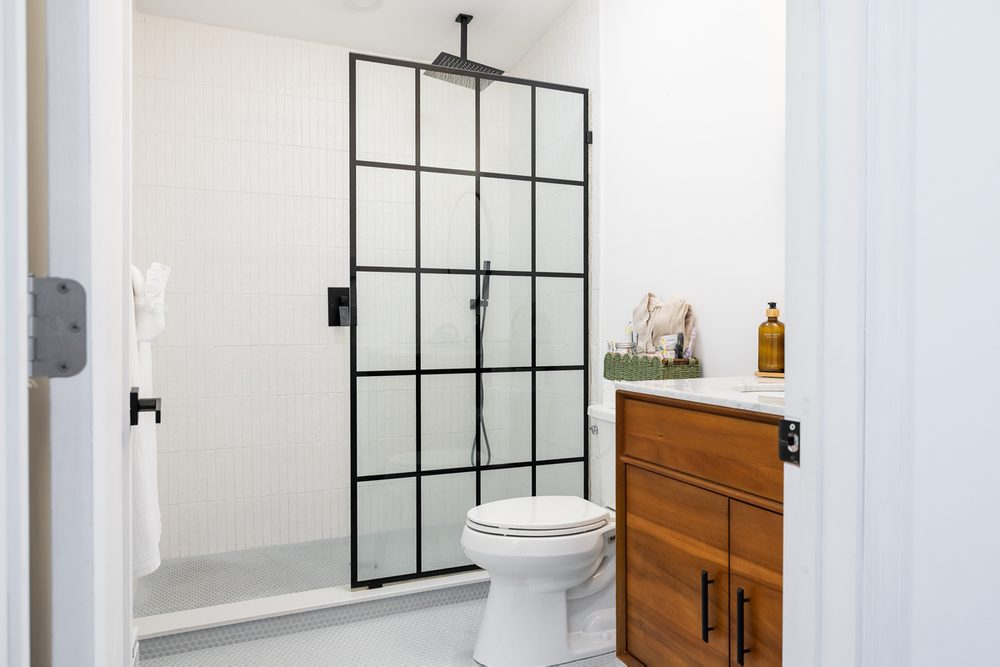 Bathroom with a walk-in glass shower and wood vanity